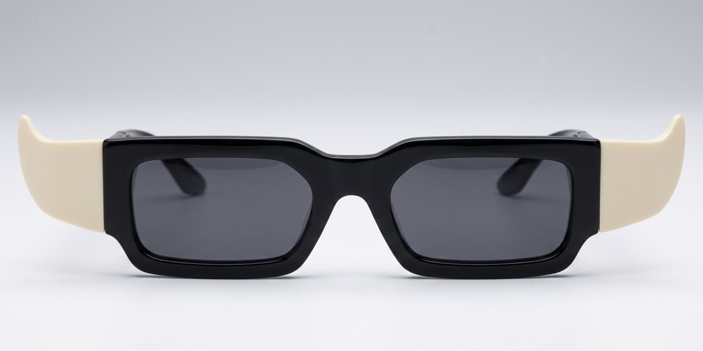 The $HORNY sunglasses: gloss-black acetate front, stepped brow line, cream arms, dark smoke lenses